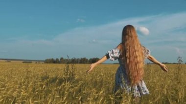 Güzellik kız açık havada zevk doğa. Bahar sahada çalışan, güneş ışığı elinde Raising elbiseli güzel genç Model kız.