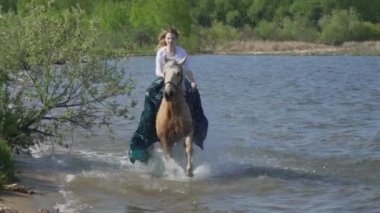 Gri atı slowmotion kadın ile suya atlar.
