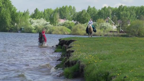 Girls on horseback along the shore — Stock Video