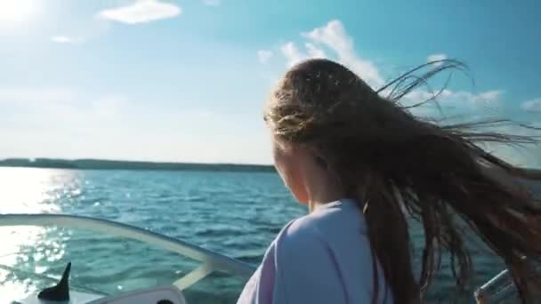Bir kadın bir tekneyi kullanıyor. Saçında Rüzgar, duygular. Güneşli hava, bir su birikintisi. — Stok video