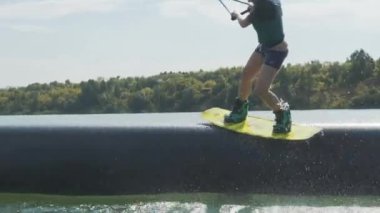Kız bir wakeboard üzerinde atlamak bir borudan