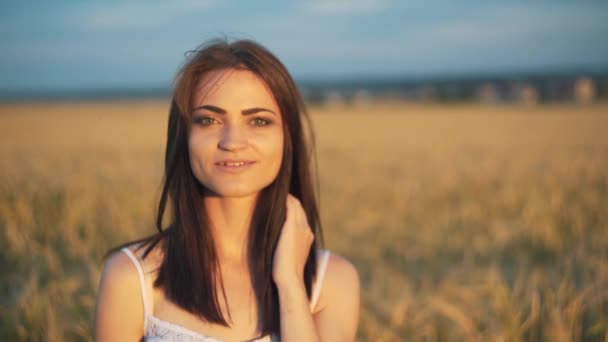 Beautiful woman with ear wheat in sunlight sunset sensual portrait in summer evening field. atmospheric moment. earth day. stylish boho girl relaxing in meadow. love to land — Stock Video
