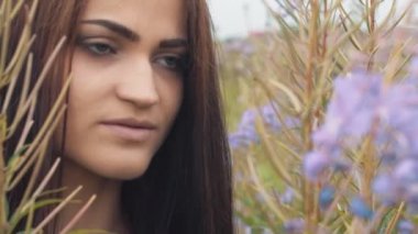 Mutlu genç kız gülümsüyor, lavantanın içinde el ele tutuşuyor. Yumuşak odaklı, yakın plan