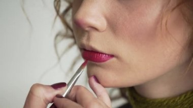 Makyöz ruj fırça ile uygulanır. Kadın modeli yüz moda parlak kırmızı dudaklar makyaj, güzellik kavramı ile yakın çekim
