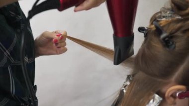 Saç boyama zaman üfleme. Uzun kahverengi saçlı bir saç kurutma makinesi ve bir yuvarlak fırça ile kurutma. Yakın çekim.