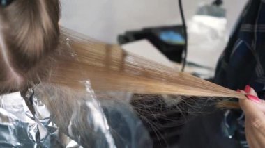 Saç boyama zaman üfleme. Uzun kahverengi saçlı bir saç kurutma makinesi ve bir yuvarlak fırça ile kurutma. Yakın çekim.