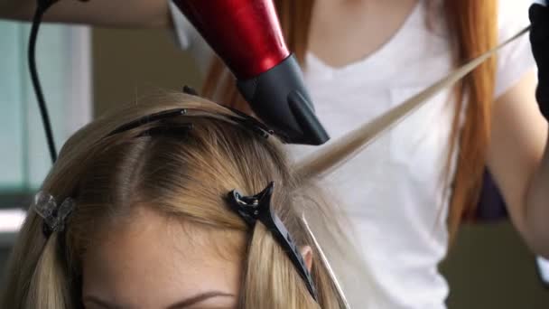 Souffler les cheveux lors de la coloration. Séchage de longs cheveux bruns avec un sèche-cheveux et une brosse ronde. Gros plan . — Video