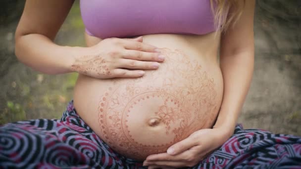 Kaukasische Schwangere mit Dreadlocks im Boho-Stil. weiße mehendi auf dickem bauch. Erwartung eines Babys im neuen Lebensstil. Bewusstes Elternkonzept. — Stockvideo
