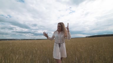 Tam uzunlukta kaçarken buğday alanda beyaz elbiseli güzel bir genç mutlu kadın portresi