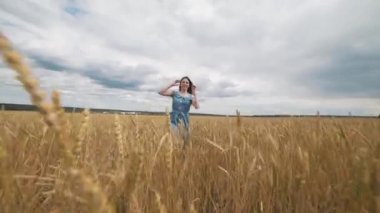 Hasat. Kız buğday dolu bir alanda. Güzel sağlıklı saçlar.