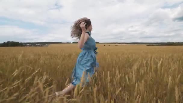 Oogsten. Meisje op een gebied van tarwe. Mooi gezond haar. — Stockvideo