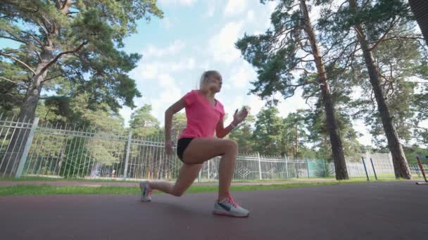 De vrouw rekt zich uit voor ze gaat joggen. Fitness en lifestyle concept. — Stockvideo