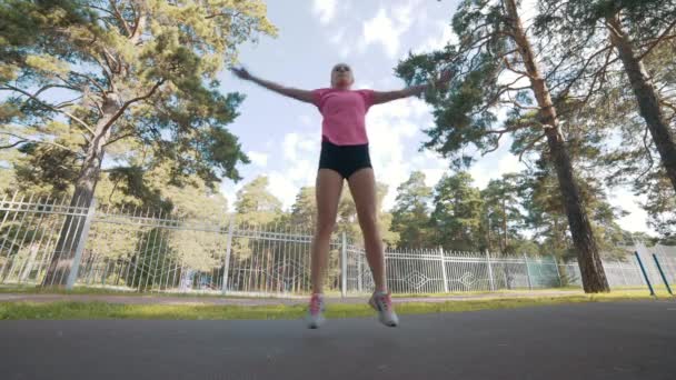 Молодая фитнес-бегунья разминается перед бегом на дорожке — стоковое видео