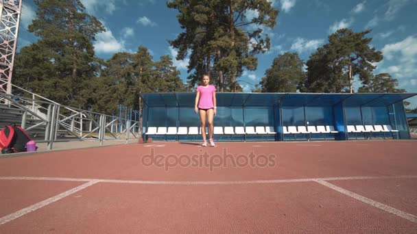 Подходящая девушка в спортивной одежде, стоящая на стартовой линии — стоковое видео