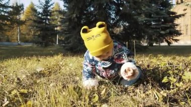 ilk alarak bebek kız parkta güzel bir sonbahar gününde adımlar.