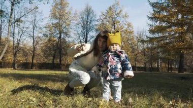 Harika trendy genç anne kızı güzel giyim ile parkta yürüyüş