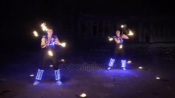 Огненное шоу, танцы с пламенем, человек в костюме Светодиодные танцы с огнем, рисует огненную фигуру в темноте — стоковое видео