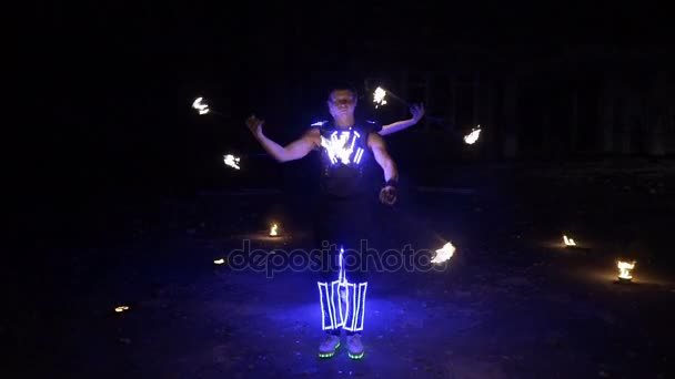 Вогняне шоу, танці з полум'ям, людина в костюмі, світлодіодні танці з вогнем, малює вогняну фігуру в темряві — стокове відео