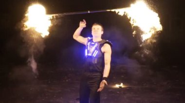 Ateş gösterisi performansını. Yakışıklı erkek ateş hokkabaz yangın baton birkaç fitil ile ile ilgili kişi düzenleme gerçekleştirme