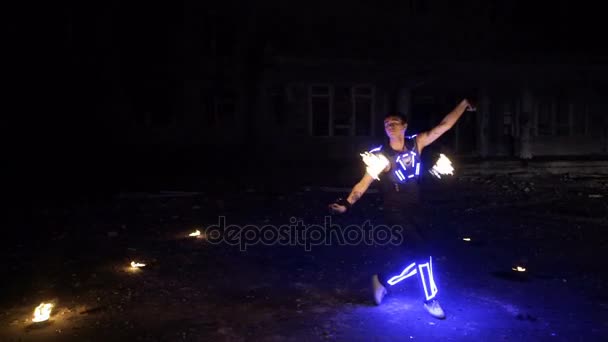 Boy shows different tricks with burning pois rotation at evening fire show. — Stock Video