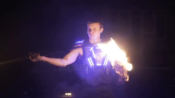 Spectacle. Beau joueur de feu masculin tourbillonnant bâton de feu avec plusieurs mèches . — Video