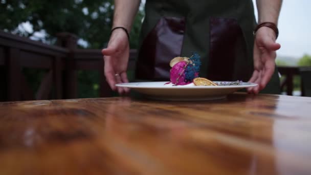 Sur une table blanche propre se trouve une assiette avec une grande glace disposée. Forme de crème glacée sous forme de purée de pommes de terre. Couleur rose. Faites pivoter la plaque. Dessert froid. Glace aux fruits . — Video