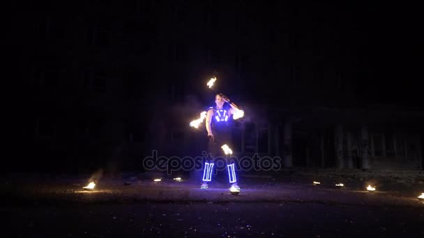 Actuación de espectáculo de fuego. Guapo artista de fuego macho girando y lanzando el bastón de fuego encendido por ambos lados . — Vídeos de Stock