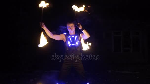 Actuación de espectáculo de fuego. Guapo artista de fuego macho girando y lanzando el bastón de fuego encendido por ambos lados . — Vídeos de Stock