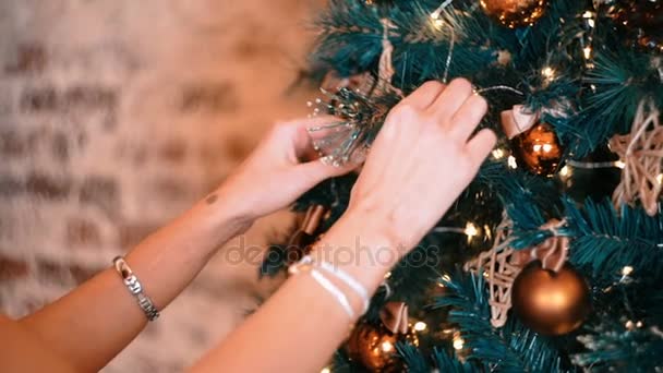 Hermosa chica en un vestido ligero decora un árbol de Navidad este año — Vídeos de Stock