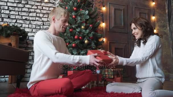 若い女性が彼女のボーイ フレンドのクリスマスのギフトを与えること — ストック動画