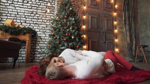 남자 고 여자 크리스마스 트리 근처 키스입니다. 진정한 사랑과 감정을 매력적인, 아름 다운, 관능적인 귀여운 친구 포옹, 명랑 한 미소를 가진 갈색 머리 여자의 근접 촬영. — 비디오