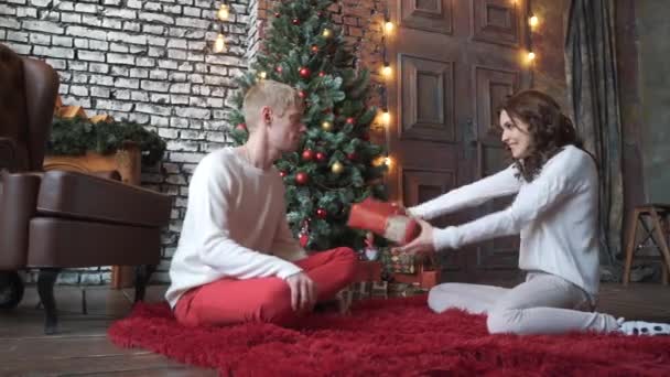 Het meisje geeft haar vriendje een cadeautje voor de kerst. — Stockvideo