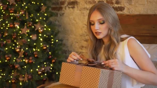 Young beautiful girl wraps a Christmas gift — Stock Video