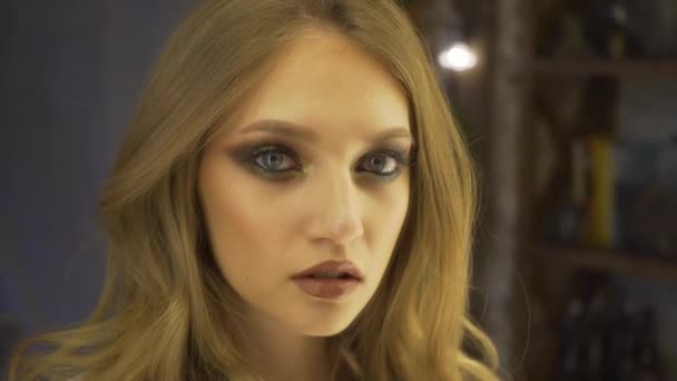 Portrét krásné, mladé a smyslná žena s krásný make-up a elegantní účes při pohledu na svůj odraz v zrcadle a oprava vlasy. Krása, móda a make-upu koncept. — Stock video