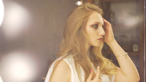 Portret van mooie, jonge en sensuele vrouw met mooie make-up en elegante kapsel haar reflectie in de spiegel te kijken en haar vaststelling. Beauty, fashion en make-up concept. — Stockvideo