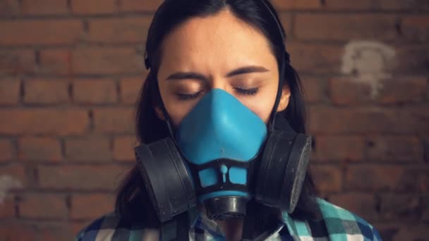 La chica se quita la máscara de la contaminación del aire. Sobre fondo de pared de ladrillo, máscara respiratoria . — Vídeo de stock