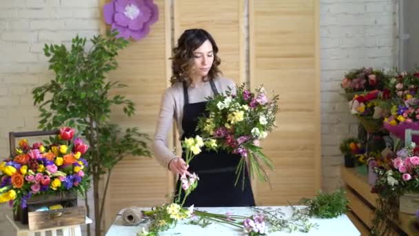 Kvinnliga florist ordna blommor i blomsteraffär — Stockvideo