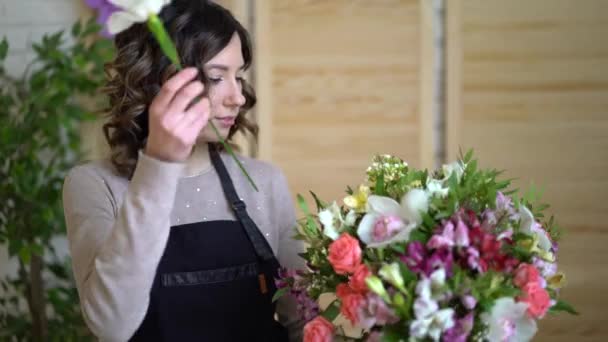 Vrouwelijke bloemist bloemschikken bloemen In Flower Shop — Stockvideo