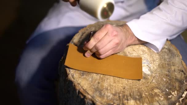 Handmatig snijden van de huid tijdens de ambachtelijke productie van lederwaren. Atelier van skinner, close-up shot weergegeven: handen van master en productieproces — Stockvideo