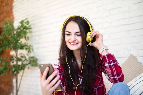 Mutlu kız evde kanepede oturan smartphone online müzik dinleme