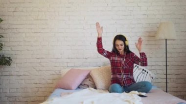 Karışık ırk kadın yatakta kulaklıklar müzik dinlemek