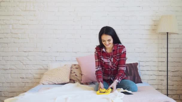 Mujer de raza mixta escuchando música en auriculares en la cama — Vídeos de Stock