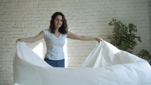 年轻漂亮的女人，整理床铺 — 图库视频影像