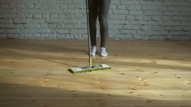 Mujer limpiando suelos de parquet en la sala de estar. Primer plano . — Vídeo de stock
