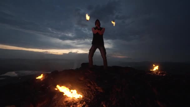 Atardecer brillante, el hombre con el fuego está en la montaña. Espectáculo de fuego . — Vídeo de stock