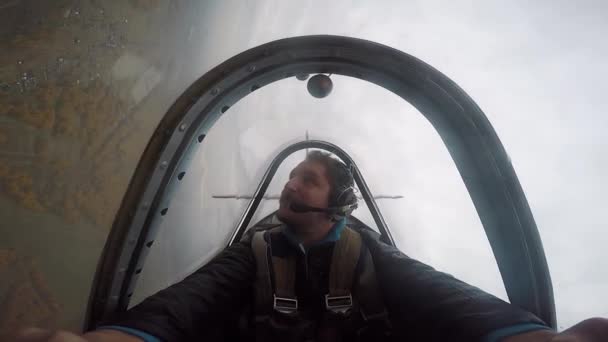 Lächelnder Pilot im Cockpit eines leichten Kunstflugzeugs, Emotionen während des Fluges, Kunstflug — Stockvideo