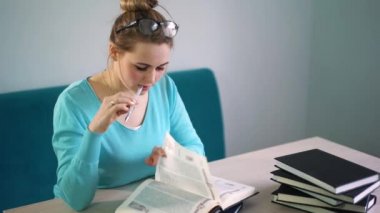 Üniversite kütüphanesinde açık kitap okuyan zeki bir öğrencinin portresi.