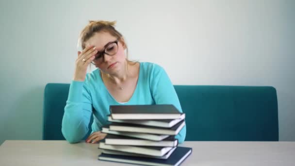 Moe, boos, uitgeput student boog haar hoofd op een stapel boeken. U hebt te veel boeken lezen. Veel werk. Sluiten. Onderwijs, mensen, kinderen en leren concept. — Stockvideo