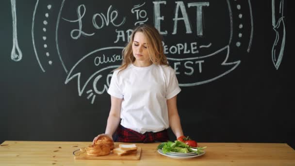 Здоровое или вредное питание, девушка перед выбором еды — стоковое видео