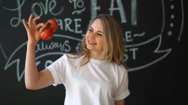 Girl with tomatoes and a leaf of salad in hands. — Stock Video